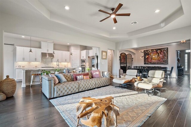 131 Katie Dr, Austin, TX 78737 - living area featuring a tray ceiling, ceiling fan, dark wood-style floors, recessed lighting, and arched walkways