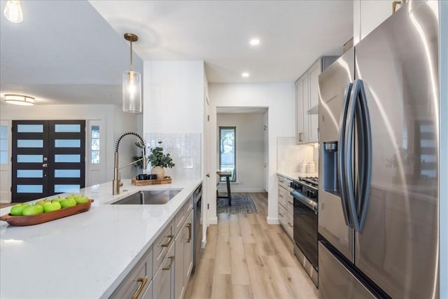 11202 Alhambra Dr, Austin, TX 78759 - kitchen featuring stainless steel appliances, light wood-style floors, light countertops, recessed lighting, and backsplash