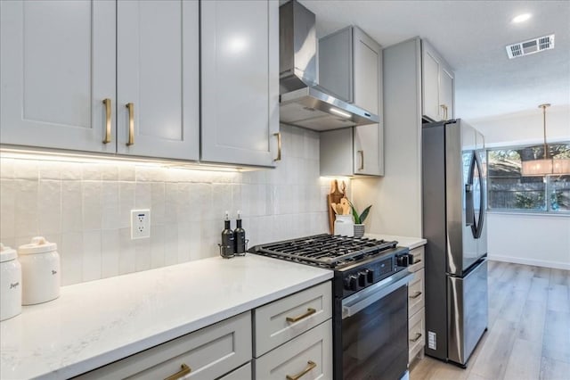 11202 Alhambra Dr, Austin, TX 78759 - kitchen featuring black range with gas cooktop, stainless steel refrigerator with ice dispenser, wall chimney range hood, light wood finished floors, and backsplash