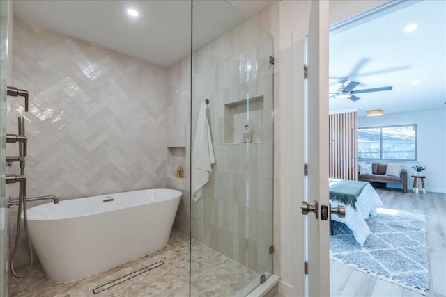 11202 Alhambra Dr, Austin, TX 78759 - ensuite bathroom featuring a freestanding tub, a stall shower, ceiling fan, wood finished floors, and recessed lighting