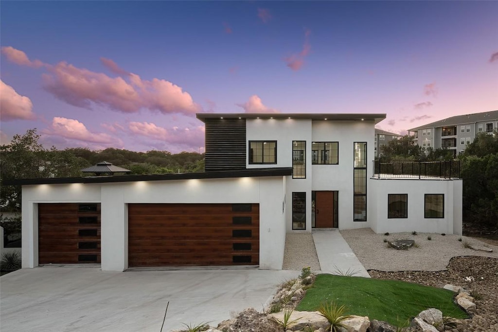 3206 Marshall Ave, Lago Vista, TX 78645 - modern home with driveway, stucco siding, a balcony, and a garage