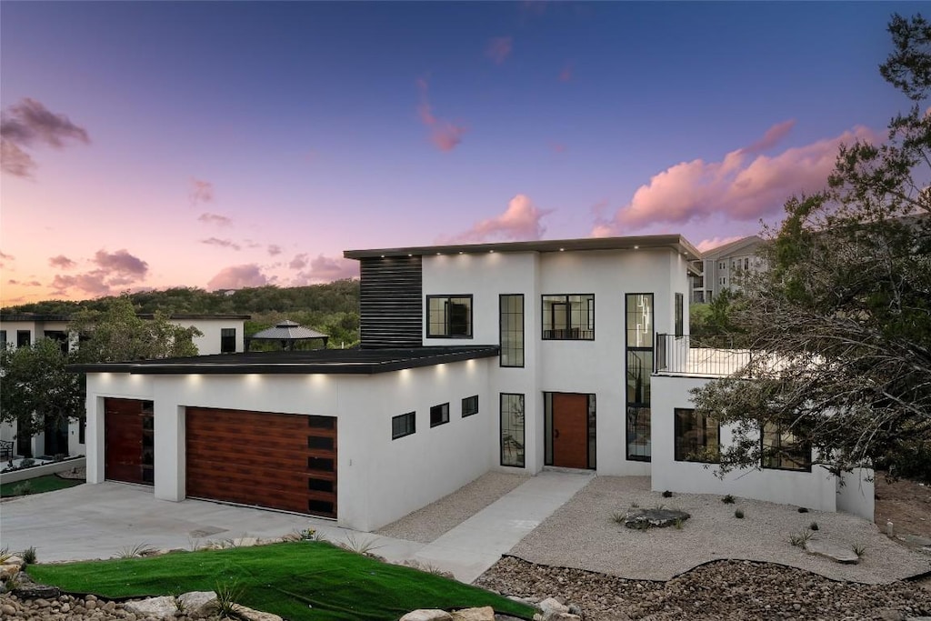 3206 Marshall Ave, Lago Vista, TX 78645 - contemporary home with an attached garage, stucco siding, and concrete driveway