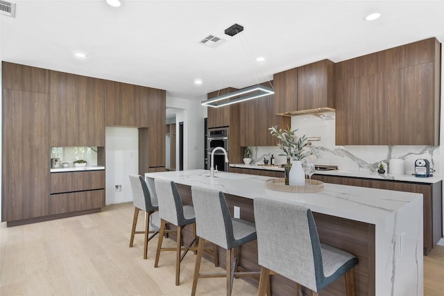 3206 Marshall Ave, Lago Vista, TX 78645 - kitchen with modern cabinets, a center island with sink, a kitchen bar, and recessed lighting