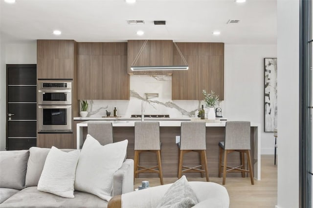 3206 Marshall Ave, Lago Vista, TX 78645 - kitchen with double oven, wall chimney range hood, light countertops, modern cabinets, and recessed lighting