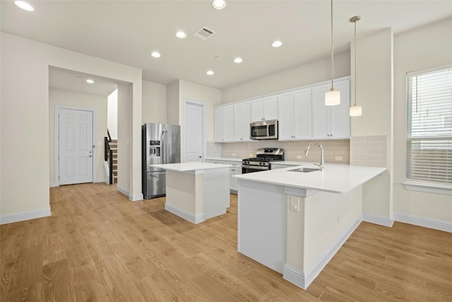 600 C-Bar Ranch Trl Unit 108, Cedar Park, TX 78613 - kitchen featuring appliances with stainless steel finishes, light wood-style flooring, backsplash, a kitchen island, and white cabinetry