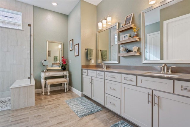 202 Iron Rail Ln, Georgetown, TX 78633 - full bathroom featuring double vanity, a walk in shower, wood finished floors, and recessed lighting