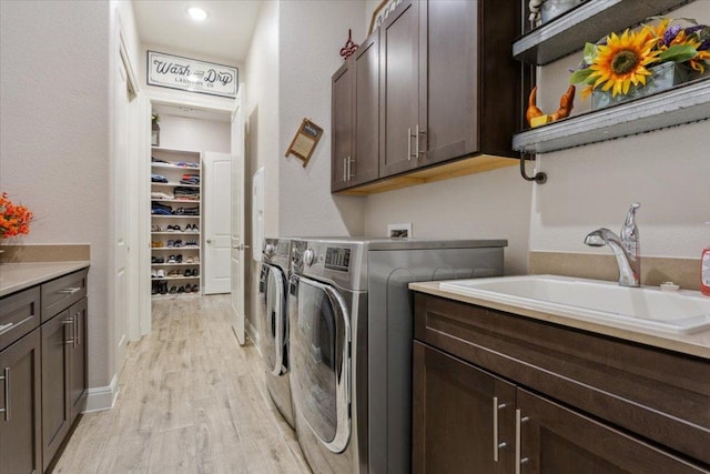 202 Iron Rail Ln, Georgetown, TX 78633 - laundry area featuring cabinet space, light wood finished floors, and washing machine and dryer