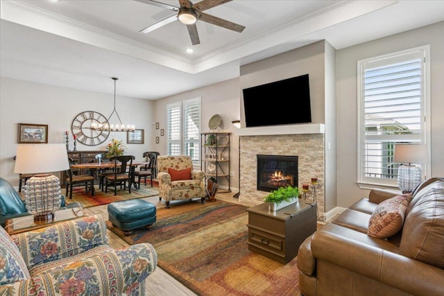 202 Iron Rail Ln, Georgetown, TX 78633 - living room featuring ceiling fan, a chandelier, a fireplace, ornamental molding, and wood finished floors