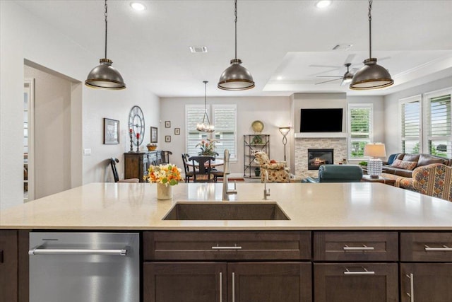 202 Iron Rail Ln, Georgetown, TX 78633 - kitchen featuring dishwasher, dark brown cabinetry, open floor plan, a ceiling fan, and a glass covered fireplace
