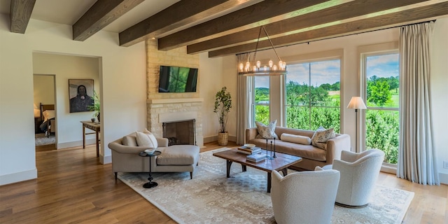 174 Putting Park Dr, Fredericksburg, TX 78624 - living room featuring plenty of natural light, a fireplace, beam ceiling, wood finished floors, and a chandelier