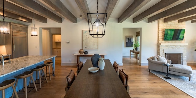 174 Putting Park Dr, Fredericksburg, TX 78624 - dining space with beamed ceiling, light wood finished floors, and a fireplace