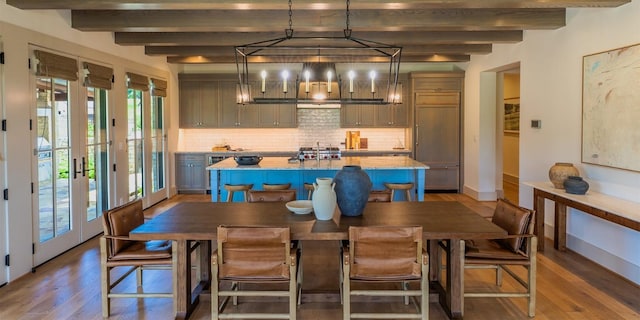 174 Putting Park Dr, Fredericksburg, TX 78624 - dining area featuring wood finished floors, beam ceiling, and a chandelier