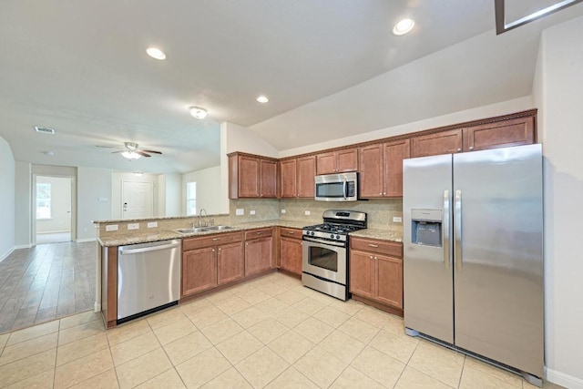 486 Nottingham Loop, Kyle, TX 78640 - kitchen with appliances with stainless steel finishes, backsplash, ceiling fan, light stone countertops, and a peninsula
