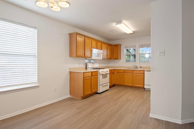 2733 Crimson Sky Ct, Round Rock, TX 78665 - kitchen featuring white appliances, light wood-style flooring, light countertops, and a chandelier