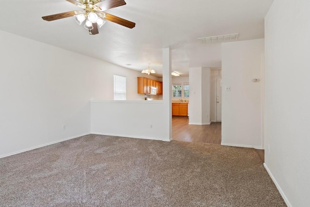 2733 Crimson Sky Ct, Round Rock, TX 78665 - unfurnished living room with light colored carpet, a ceiling fan, and a chandelier