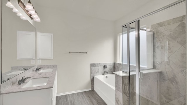 12505 Franklin D Roosevelt St, Manor, TX 78653 - bathroom with double vanity, a garden tub, a marble finish shower, and wood finished floors