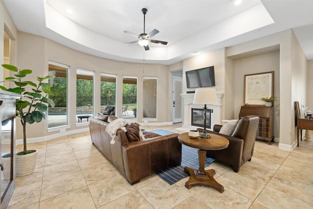 11516 Shoreview Overlook, Austin, TX 78732 - living area featuring a tray ceiling, a ceiling fan, a glass covered fireplace, light tile patterned floors, and recessed lighting