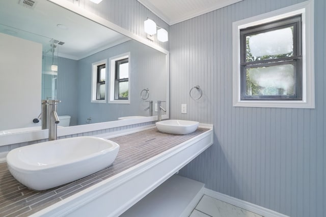 2616 Aylesbury Ln, Austin, TX 78745 - full bath featuring ornamental molding, double vanity, and marble look tile flooring