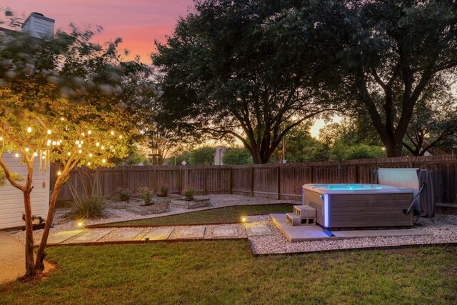 2616 Aylesbury Ln, Austin, TX 78745 - yard at dusk with a hot tub, a fenced backyard, and a patio