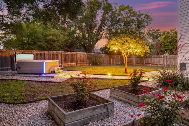 2616 Aylesbury Ln, Austin, TX 78745 - yard at dusk with a hot tub, a vegetable garden, and a fenced backyard