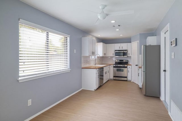 2616 Aylesbury Ln, Austin, TX 78745 - kitchen with stainless steel appliances, ceiling fan, tasteful backsplash, light countertops, and white cabinets