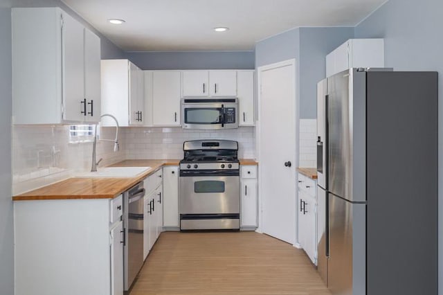 2616 Aylesbury Ln, Austin, TX 78745 - kitchen with stainless steel appliances, tasteful backsplash, white cabinets, and recessed lighting