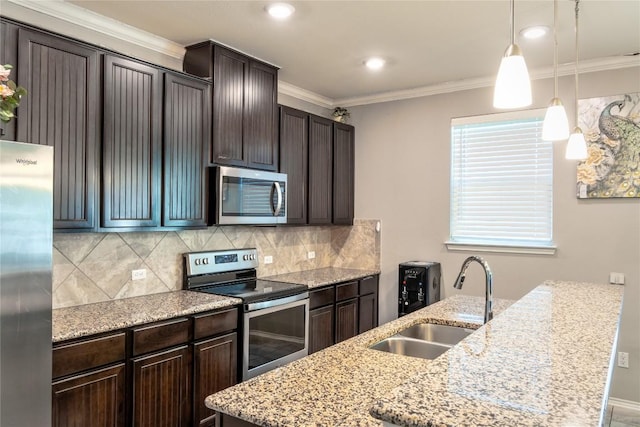 2471 Sunrise Rd Unit 35, Round Rock, TX 78664 - kitchen featuring appliances with stainless steel finishes, dark brown cabinetry, tasteful backsplash, ornamental molding, and pendant lighting
