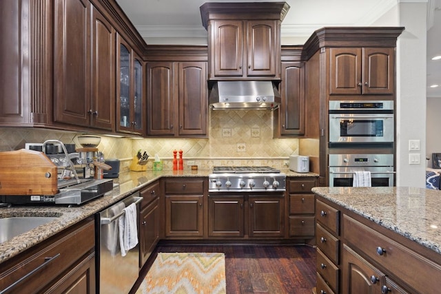1036 Liberty Park Dr Unit 46, Austin, TX 78746 - kitchen featuring appliances with stainless steel finishes, extractor fan, crown molding, light stone counters, and dark wood-type flooring