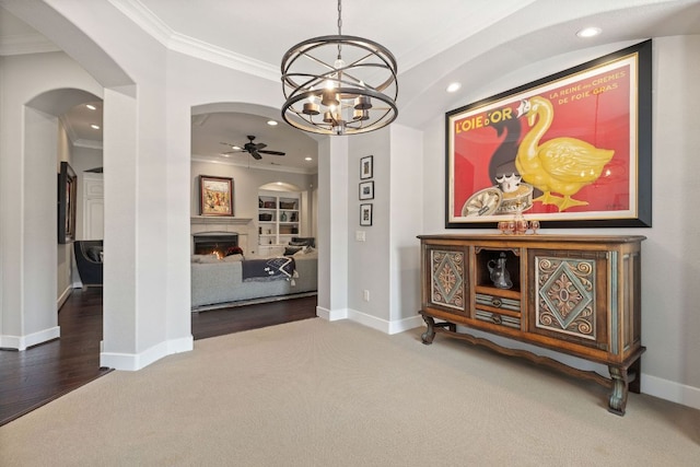 1036 Liberty Park Dr Unit 46, Austin, TX 78746 - dining room featuring carpet floors, ceiling fan, ornamental molding, a warm lit fireplace, and arched walkways