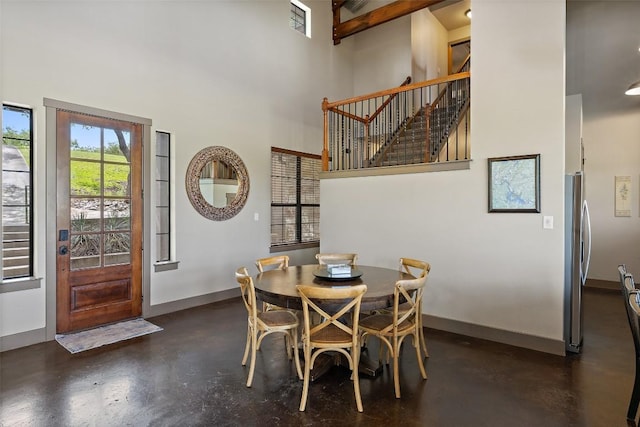 186 Sleepy Oaks Dr, Kingsland, TX 78639 - dining area featuring finished concrete floors, a towering ceiling, and stairway