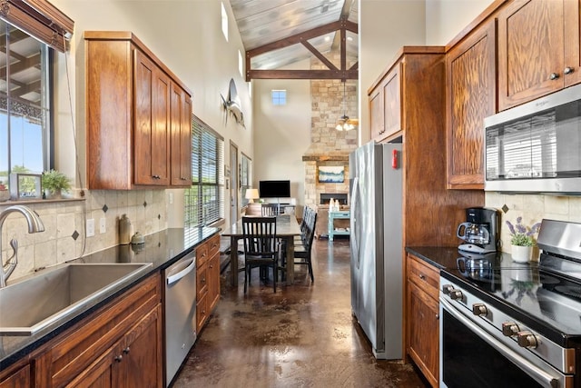 186 Sleepy Oaks Dr, Kingsland, TX 78639 - kitchen featuring stainless steel appliances, concrete floors, dark countertops, backsplash, and high vaulted ceiling