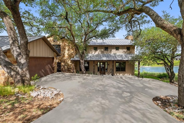 186 Sleepy Oaks Dr, Kingsland, TX 78639 - view of front facade featuring a metal roof, a standing seam roof, a water view, and board and batten siding