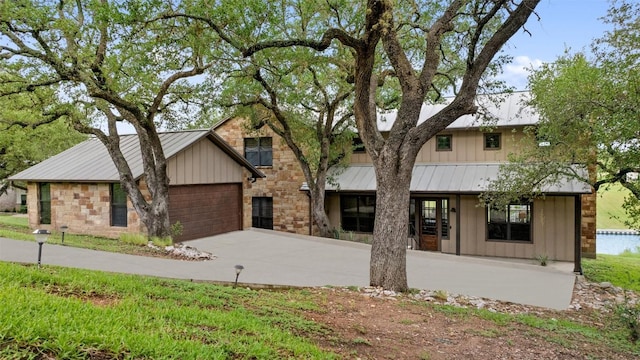186 Sleepy Oaks Dr, Kingsland, TX 78639 - view of front facade featuring board and batten siding, driveway, a standing seam roof, and a metal roof