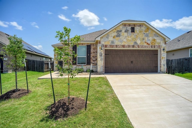 1928 Dragonfly Loop, Bastrop, TX 78602 - view of front of house featuring a garage, driveway, and stone siding