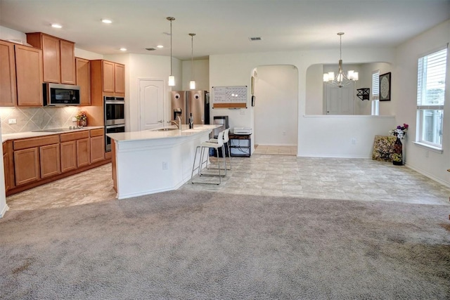 1928 Dragonfly Loop, Bastrop, TX 78602 - kitchen with stainless steel appliances, a chandelier, backsplash, brown cabinets, and recessed lighting