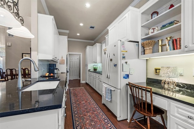 7815 Moritz Ln, Austin, TX 78731 - kitchen featuring freestanding refrigerator, crown molding, white cabinetry, dark wood-style floors, and recessed lighting