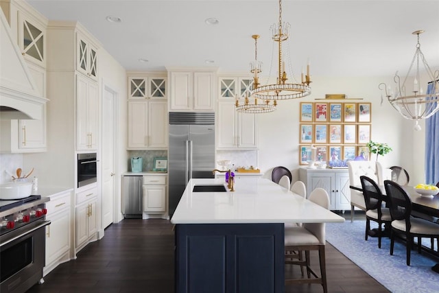 303 Marina View Ct Unit 23A, Austin, TX 78734 - kitchen featuring high quality appliances, a chandelier, dark wood-style flooring, custom range hood, and an island with sink