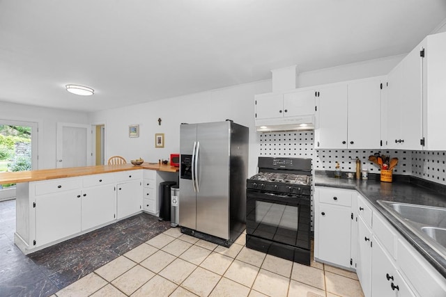 1209 Clearfield Dr, Austin, TX 78758 - kitchen featuring black gas range, stainless steel fridge, under cabinet range hood, a peninsula, and white cabinetry