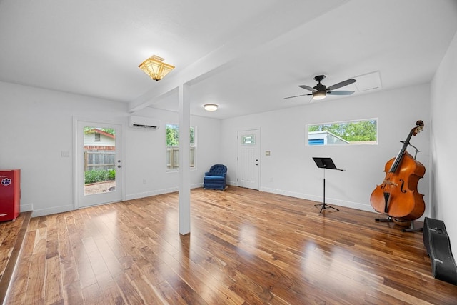 1209 Clearfield Dr, Austin, TX 78758 - exercise area featuring ceiling fan, a wall mounted air conditioner, and wood finished floors