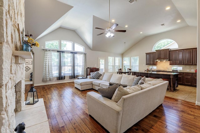 2843 Nolina Ln, Round Rock, TX 78681 - living room with light wood-style floors, a ceiling fan, recessed lighting, high vaulted ceiling, and a fireplace with flush hearth