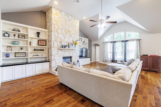 2843 Nolina Ln, Round Rock, TX 78681 - living room featuring ceiling fan, a fireplace, hardwood / wood-style flooring, high vaulted ceiling, and arched walkways