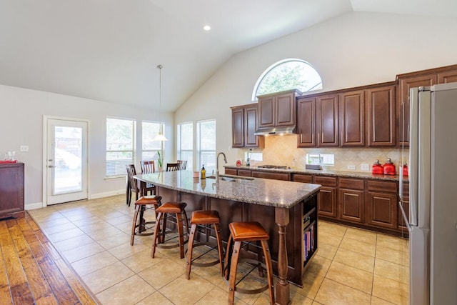 2843 Nolina Ln, Round Rock, TX 78681 - kitchen featuring stainless steel appliances, a kitchen bar, stone counters, a kitchen island with sink, and decorative backsplash