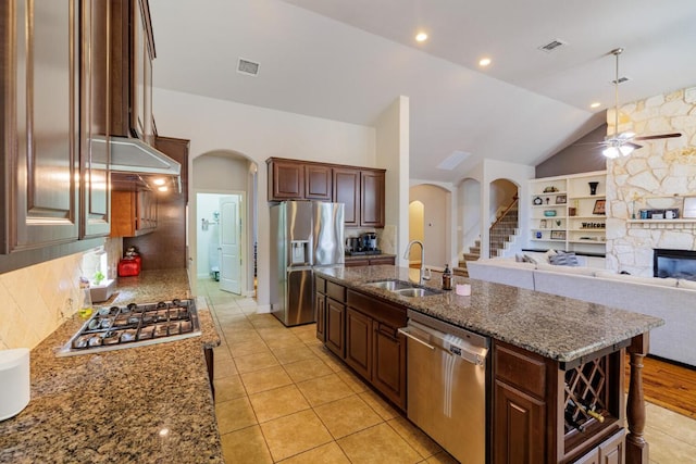 2843 Nolina Ln, Round Rock, TX 78681 - kitchen with appliances with stainless steel finishes, arched walkways, a ceiling fan, a fireplace, and vaulted ceiling