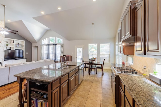 2843 Nolina Ln, Round Rock, TX 78681 - kitchen with light tile patterned flooring, stainless steel appliances, a ceiling fan, lofted ceiling, and dark stone counters