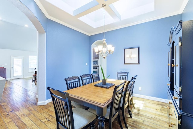 2843 Nolina Ln, Round Rock, TX 78681 - dining area with arched walkways, ornamental molding, a skylight, light wood-type flooring, and a chandelier