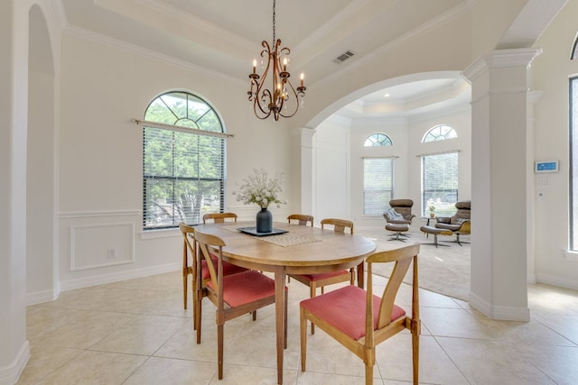 1003 Overlook Bnd, Leander, TX 78641 - dining space featuring a raised ceiling, light tile patterned floors, arched walkways, crown molding, and ornate columns
