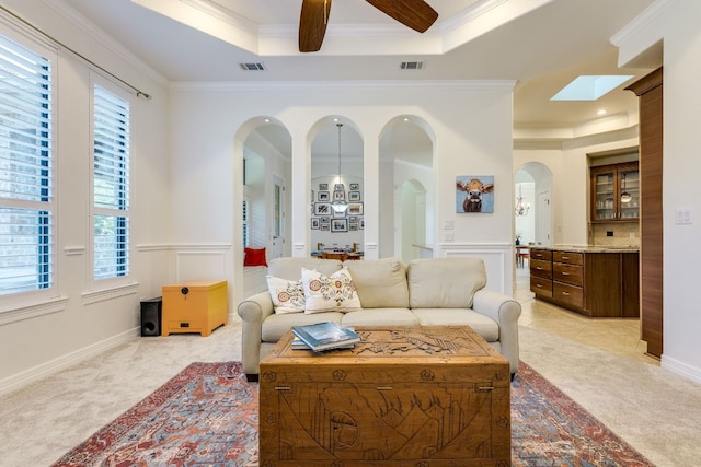 1003 Overlook Bnd, Leander, TX 78641 - living area with arched walkways, ornamental molding, light carpet, and a tray ceiling