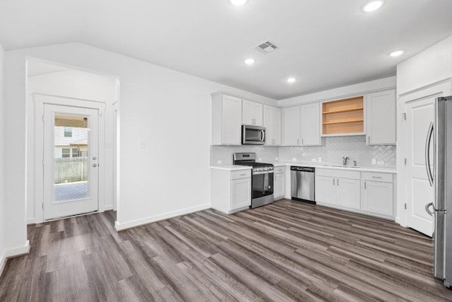 225 Lambert St, Leander, TX 78641 - kitchen featuring appliances with stainless steel finishes, open shelves, dark wood finished floors, light countertops, and recessed lighting
