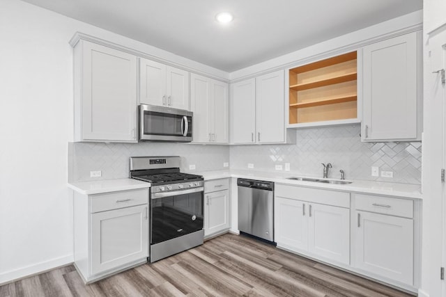 225 Lambert St, Leander, TX 78641 - kitchen with stainless steel appliances, light countertops, open shelves, light wood finished floors, and recessed lighting