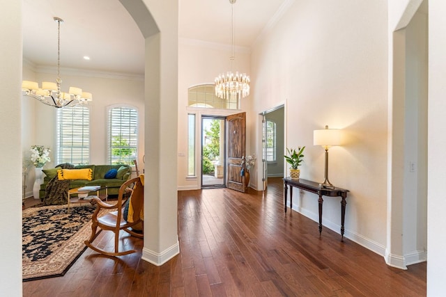 1821 Gilded Crest Dr, Leander, TX 78641 - entryway featuring a chandelier, arched walkways, dark wood finished floors, and crown molding